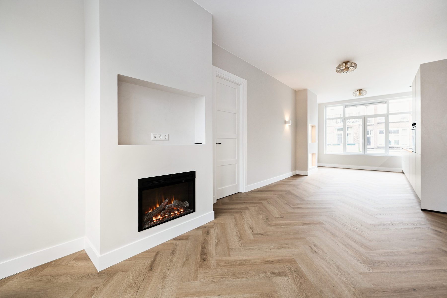 Woonkamer met ingebouwde haard en visgraatvloer